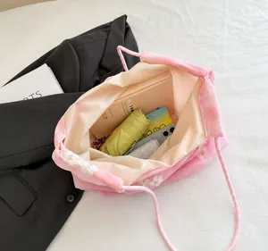 Detailed interior of pink floral tote showing a book, umbrella, and phone inside