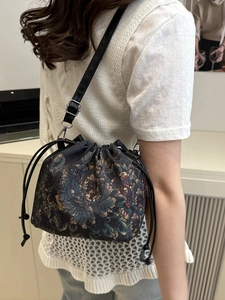 Sac seau rétro à cordon avec motif floral et bandoulière en cuir porté par un mannequin