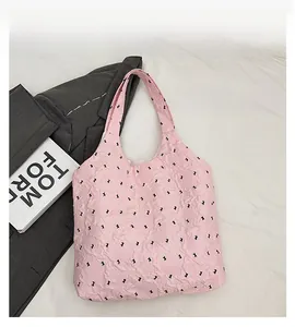 Detailed texture of pink tote bag featuring black rabbit patterns and ruffled fabric