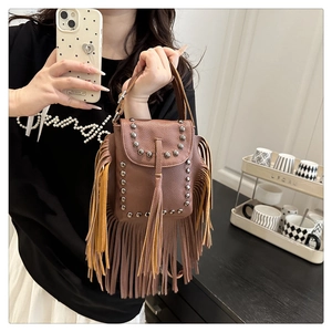 Detalle de bolso vintage de cuero marrón con remaches plateados y flecos boho