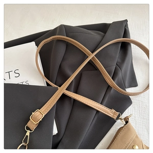 Close-up of tan leather shoulder strap with gold hardware and fine stitching detail