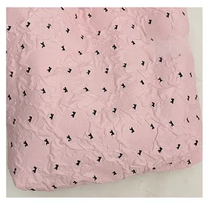 Macro shot of pink textured tote bag fabric featuring small black bow-knot prints