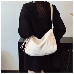 Dettaglio borsa hobo bianca a mezzaluna con coulisse a contrasto e tracolla larga