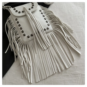 Primo piano della borsa in ecopelle bianca con rivetti metallici e lunghe nappe a frangia