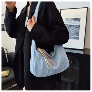 Detail of light blue hobo bag with distinctive red and white woven rope zipper pullers