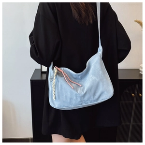 Detailed back view of a light blue nylon crescent tote bag with knot charm decoration