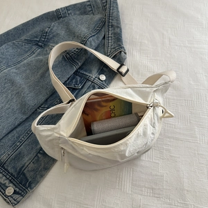 Vue détaillée de l'intérieur du sac besace blanc montrant un grand espace de rangement