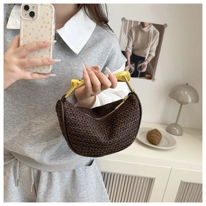 Detail of dark brown woven crescent bag with unique gold metallic handle