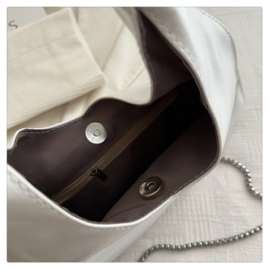Nahaufnahme von weißem Lederhandtaschen-Interieur mit Reißverschluss und Magnetverschluss