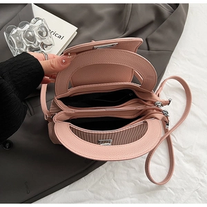 Detail of pink pebbled leather handbag with double compartments and smooth zipper