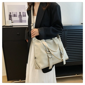 Asian model wearing a beige large capacity tote bag in a minimalist indoor setting