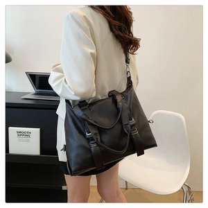 Detail of vintage large capacity leather tote bag with round handles and metal hardware