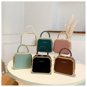 Detail showing various colors of octagonal leather handbags with gold metal frames