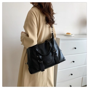 Detail of vintage black soft leather tote bag with silver D-rings and parallel buckles