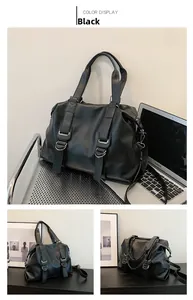 Detail view of the black leather tote bag featuring metal D-rings and adjustable strap