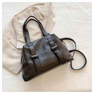 Detail of deep brown PU leather tote with metal buckles and detachable shoulder strap