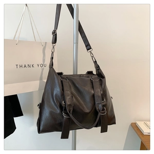 Detail view of large dark brown retro tote bag with PU leather texture and metal rings