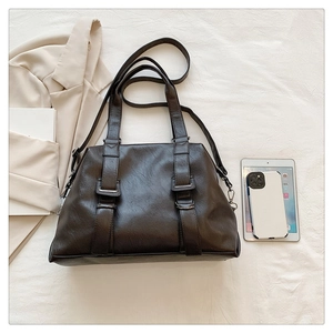 Detail of dark brown vintage tote bag with dual straps and textured faux leather finish
