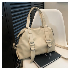 Detailed macro view of beige PU leather tote featuring silver D-ring and neat stitching
