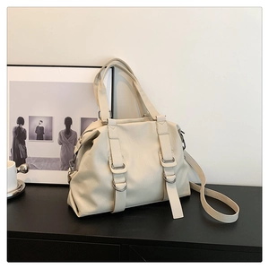 Detail of cream white tote bag with silver metal ring and soft synthetic leather texture