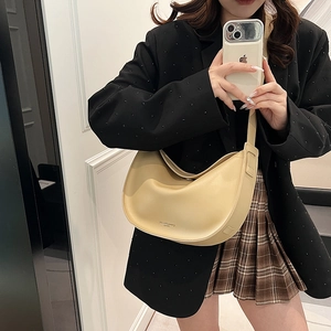 Fashionable beige crescent tote bag made of smooth faux leather with adjustable strap