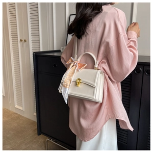 Chic cream leather square handbag with orange scarf detail and gold hardware clasp