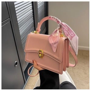 Pink leather handbag with decorative floral silk scarf and gold twist lock detail