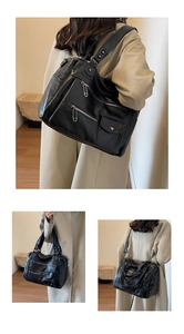 Detail view of large black crossbody bag showing vintage texture and multi-pocket design