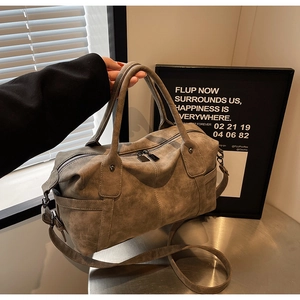 Detailaufnahme der taupefarbenen Retro-Boston-Tasche mit Nieten und Doppelgriffen