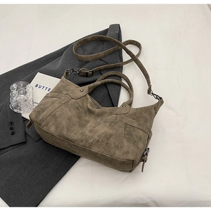 Detail der Vintage-Tragetasche mit abgenutzter Lederstruktur und Retro-Metallschnalle