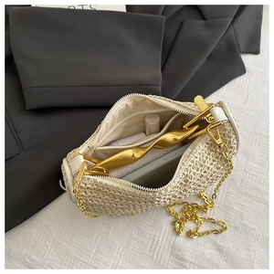 Close-up of beige woven bag interior with functional compartments and gold chain strap