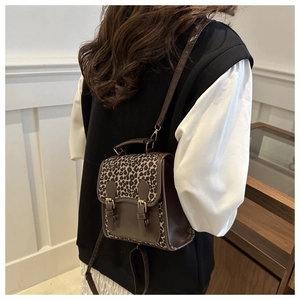 Detalle de mochila vintage de leopardo con hebillas dobles y correas de cuero suave