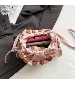 Top view of pink drawstring crossbody bag showing spacious interior with beads handle