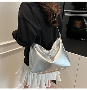 Modern metallic silver hobo bag worn on shoulder showing large capacity and soft texture