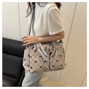 Detail of grey corduroy tote bag featuring bow patterns and multiple functional pockets