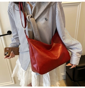 Detailed view of large red hobo tote bag in matte synthetic leather with shoulder strap