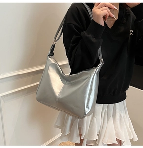 Detail of large silver metallic tote bag with high-gloss finish and natural creases