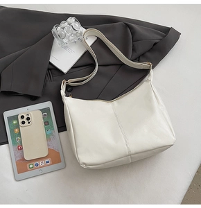 Detail of cream faux leather tote bag with pebble texture and matte gold zipper hardware