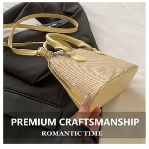 Detail of light yellow woven handbag with leather trim and adjustable shoulder strap