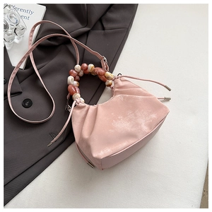 Pink dumpling bag with marble beaded handle and drawstring closure in detail view