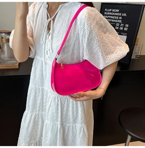 Detail of rose pink patent leather hobo bag with gold zipper and slim shoulder strap