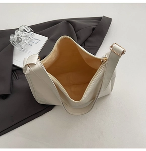 Close-up of large beige tote bag featuring gold hardware and spacious interior
