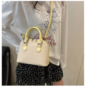 Detail view of beige woven handbag with pale yellow handles and Fashion & Bags text