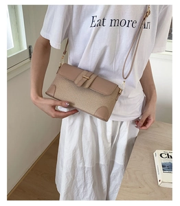 Detail showing woven texture and smooth leather trim on a stylish baguette underarm bag