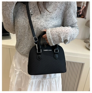Close-up of black shell bag showing textured leather and Fashion & Bags text detail