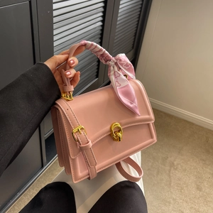 Pink rectangular handbag with gold twist-lock and decorative floral silk scarf handle