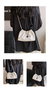 Detailed view of a white woven cloud bag with silver chain strap and pearl charm detail