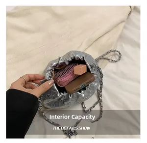 Detailed internal capacity view of silver quilted crossbody bag with items inside