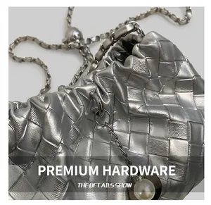 Detail of silver woven texture purse with metallic chain and pearl charm detail
