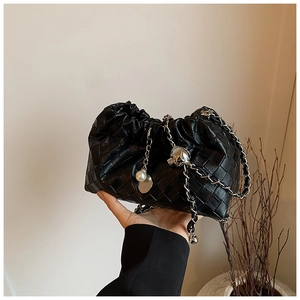 Close-up of black woven cloud bag featuring pearl pendant and silver metal chain strap